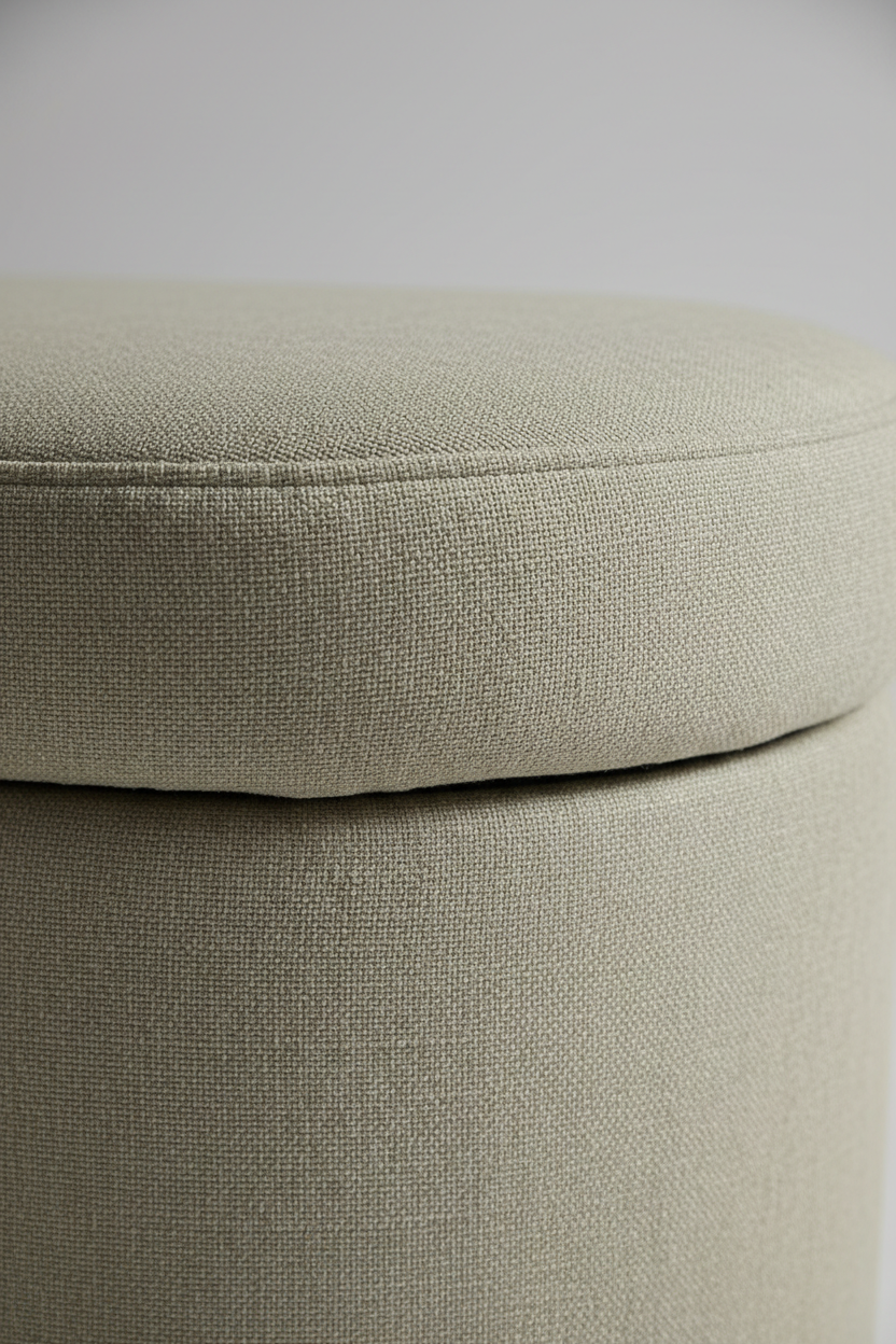 Corner detail of rounded edge and linen stitching on sage beige storage ottoman